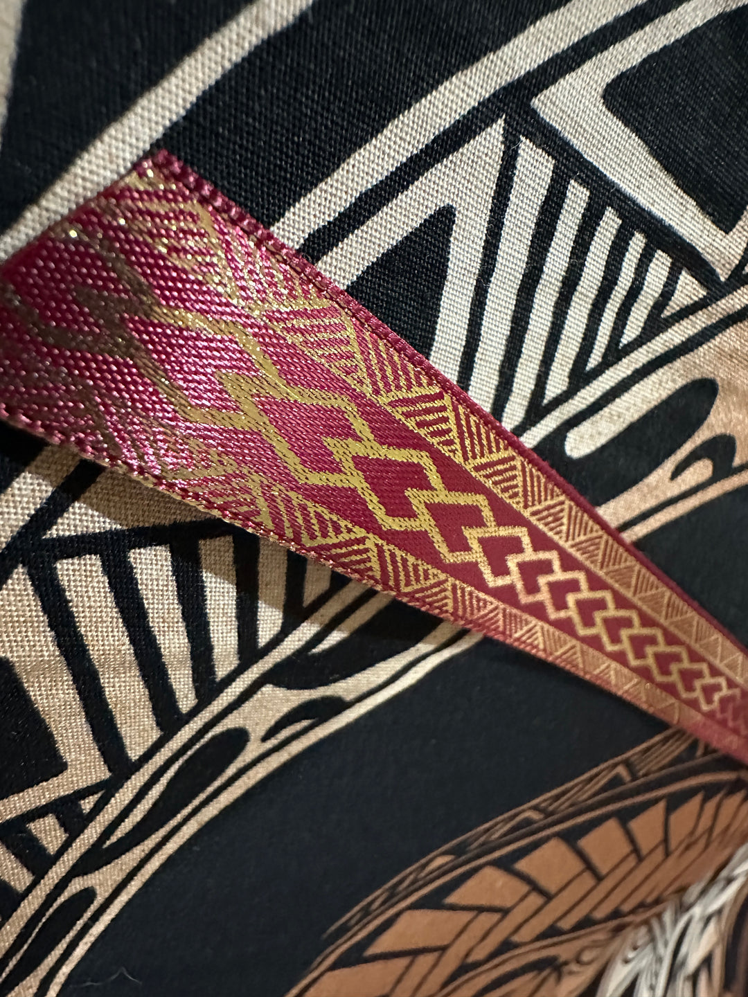 5/8” wide maroon satin ribbon with metallic gold tribal design