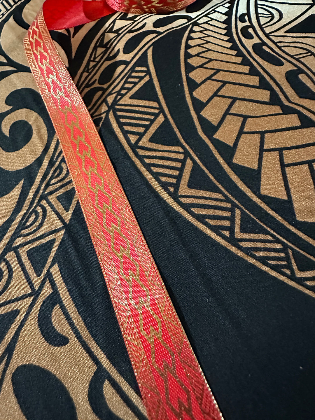 5/8” wide red satin ribbon with metallic gold tribal design